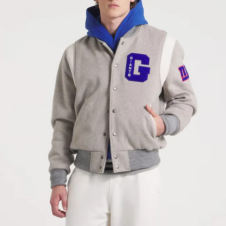 Person wearing a gray varsity jacket with blue hood and 'GIANTS' logo on a white background in USA