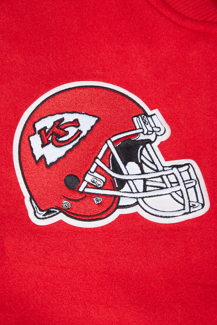 Close-up of the Kansas City Chiefs red helmet logo with detailed embroidery on red fabric.